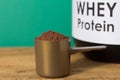Whey Protein. Close up of scoop with chocolate powder and black Royalty Free Stock Photo