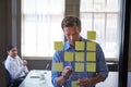 Which concept do you think we should pitch first. two businessmen preparing for a presentation by using adhesive notes.