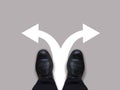 Which way - direction choices and decisions for businessman in black shoes with left and right directional arrows - business conce Royalty Free Stock Photo