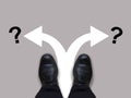 Which way - direction choices and decisions for businessman in black shoes with left and right directional arrows and question mar