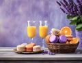 Whicker basket with purple and orange macarons near lavender flowers, fresh oranges and orange juice Royalty Free Stock Photo