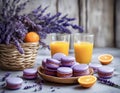 Whicker basket with purple and orange macarons near lavender flowers, fresh oranges and orange juice Royalty Free Stock Photo