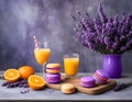 Whicker basket with purple and orange macarons near lavender flowers, fresh oranges and orange juice Royalty Free Stock Photo