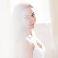 Whimsical beauty. Portrait of a young woman standing in front of a window.