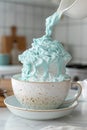 Whimsical Blue Whipped Cream Overflowing in a Speckled Ceramic Cup on Kitchen Counter