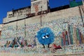 Whimsical scene with street art depicting colorful blue creature, Worcester, Mass, 2020