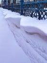 Whimsical overhanging wavy drifts blown with the wind through the fence