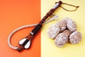 Whip and gingerbread on a two-tones contrast background. Threats and promises concept. Combination of reward and punishment t