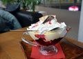 Whipped cream with hot fruits on a glass bowl.