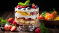 Whipped cream on layers of sponge cake, fruit, custard in glass trifle. Mix of textures and flavors