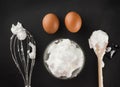 Whipped egg whites for cream in a glass bowl, whisk and wooden s Royalty Free Stock Photo