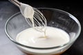Whipped egg whites in a glass mixing bowl with a whisk. generative AI Royalty Free Stock Photo
