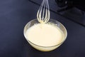 Whipped eggs in glass bowl on kitchen