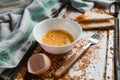 Whipped with a fork and mixed raw egg broken into a white bowl with yolk and protein, next to the shell, fork and towel Royalty Free Stock Photo