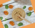 Whipped honey with apricot on a table in a jar with a spoon spindle, next to dried apricots and mint, top view Royalty Free Stock Photo