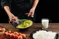 Whipping eggs. Chef hands close-up whisk eggs on a black background. Natural light, slightly toned image. Copy space Royalty Free Stock Photo