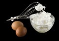 Whipping eggs with whisk and eggs isolated on black background Royalty Free Stock Photo