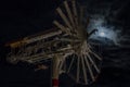 A whirligig spins in front of a full moon