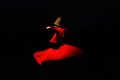 Whirling dervish on black background in red costume