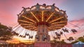 Whirling in Sunset Hues: The Mesmerizing Flight of a Pink Carousel Ride. Generative AI Royalty Free Stock Photo