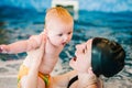 Whirlpool, jacuzzi. Diving baby in the paddling pool. Young mother, swimming instructor and happy little girl in pool. Learn Royalty Free Stock Photo