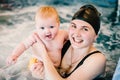 Whirlpool, jacuzzi. Diving baby in the paddling pool. Young mother, swimming instructor and happy little girl in pool. Learn Royalty Free Stock Photo