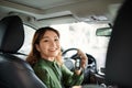 In whirlwind of life. Pretty smiling vivacious beautiful young woman holding keys and keeping wheel while driving a car Royalty Free Stock Photo