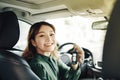 In whirlwind of life. Pretty smiling vivacious beautiful young woman holding keys and keeping wheel while driving a car Royalty Free Stock Photo