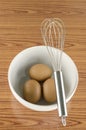 Whisk and egg in white bowl Royalty Free Stock Photo