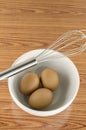 Whisk and egg in white bowl Royalty Free Stock Photo