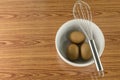 Whisk and egg in white bowl Royalty Free Stock Photo