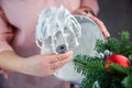 The whisk of an electric mixer in a white mass of meringue with standing peaks is held in the hand of a pastry chef