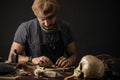 Whiskered shoemaker with making measurments in patterns at table in workshop Royalty Free Stock Photo