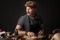 Whiskered shoemaker with making measurments in patterns at table in workshop