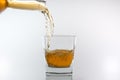 Whiskey being poured into a glass against white background Royalty Free Stock Photo