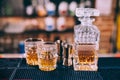 Whiskey bottle, crystal glasses and cocktail tools in modern bar, on counter Royalty Free Stock Photo