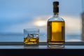 Whiskey with bottle by the window Royalty Free Stock Photo