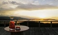 A whiskey or brandy bottle with a clear bottle design and clear glass placed on a wooden table. Wooden balcony for mountain views Royalty Free Stock Photo