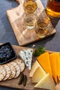 Whiskey and cheese pairing, tasting whisky glasses and plate with sliced cheeses