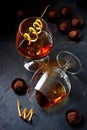 Whiskey with chocolate candy on dark background