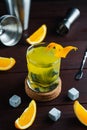 Whiskey cocktail in glass with natural cube stones and orange peel. Jagger and shaker at background