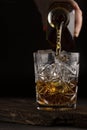 Whiskey or cognac is poured into an old fashioned glass, close up
