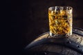 Whiskey drink. Glass of whiskey on old wooden barrel Royalty Free Stock Photo