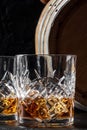 Whiskey in a glass with a barrel. Bourbon whisky and a cask on a dark background Royalty Free Stock Photo