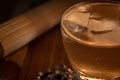 whiskey glass with ice over wood background