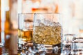 Whiskey glass with ice and warm light on black table with reflection, warm atmosphere Royalty Free Stock Photo