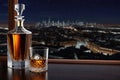 Whiskey glass jag decanter on wooden counter with view to night city Royalty Free Stock Photo