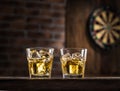 Whiskey glasses or glasses of whiskey with ice cubes on the wooden table