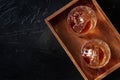 Whiskey in glasses with ice. Bourbon whisky on rocks on a black slate background Royalty Free Stock Photo