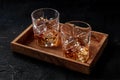 Whiskey in glasses with ice. Bourbon whisky on rocks on a dark background Royalty Free Stock Photo
